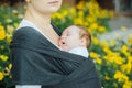 Mother carrying sleeping newborn baby in a sling Royalty Free Stock Photo