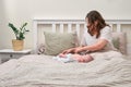 The mother changes the child clothes in the bedroom. A lonely woman with a newborn baby is lying alone in an empty bed Royalty Free Stock Photo