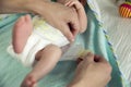 Mother changes diapers to her newborn baby. Motherhood daily routine. Family lifestyle.