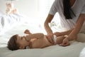 Mother changing baby`s diaper on bed Royalty Free Stock Photo