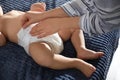 Mother changing baby`s diaper on bed at home Royalty Free Stock Photo