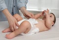 Mother changing baby`s diaper on bed at home, closeup Royalty Free Stock Photo