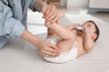 Mother changing baby`s diaper on bed at home, closeup Royalty Free Stock Photo