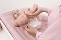Mother changing baby`s diaper at home, focus on hands Royalty Free Stock Photo