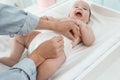 Mother changing baby`s diaper at home, focus on hands Royalty Free Stock Photo