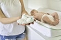 A mother Changing Baby`s Diaper In nursery holding diaper Royalty Free Stock Photo