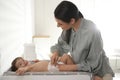 Mother changing baby`s diaper on table Royalty Free Stock Photo