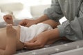 Mother changing baby`s diaper on table, closeup Royalty Free Stock Photo