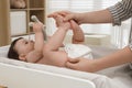 Mother changing baby`s diaper on table at home, closeup Royalty Free Stock Photo