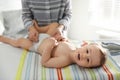 Mother changing baby`s diaper on table Royalty Free Stock Photo