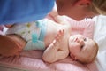Mother Changing Baby Son's Nappy As He Lies On Mat Royalty Free Stock Photo