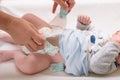 Mother changing diaper of adorable baby with a hygiene set for babies on the background Royalty Free Stock Photo