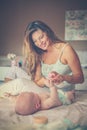Mother changing diaper her little baby on the bed. Royalty Free Stock Photo
