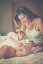 Mother changing diaper her little baby on the bed. Mother using Royalty Free Stock Photo