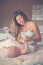 Mother changing diaper her little baby on the bed. Mother using Royalty Free Stock Photo