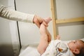 Mother changing diaper to baby, lifting her little legs Royalty Free Stock Photo