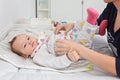 Mother changing diapers of a nine months old baby girl daughter Royalty Free Stock Photo