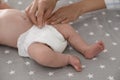 Mother changing her baby`s diaper on bed Royalty Free Stock Photo