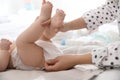 Mother changing her baby`s diaper on bed Royalty Free Stock Photo