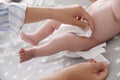 Mother changing her baby`s diaper on bed Royalty Free Stock Photo