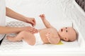Mother changing her baby`s diaper on table Royalty Free Stock Photo