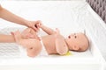 Mother changing her baby`s diaper on table Royalty Free Stock Photo