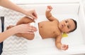 Mother changing her baby`s diaper on table Royalty Free Stock Photo