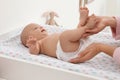 Mother changing her baby`s diaper on table at home Royalty Free Stock Photo