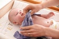 Mother changing infant baby clothes on the table, detail to her smiling boy Royalty Free Stock Photo