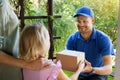 mother with child accepting home delivery package from delivery man at house front door Royalty Free Stock Photo