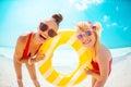 Mother and child on beach holding yellow inflatable lifebuoy