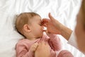 Mother child bonding concept. Little baby girl holding mom fingers, lying on bed at home, above view Royalty Free Stock Photo