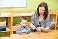 Mother and child boy drawing together with color pencils in preschool at table in kindergarten Royalty Free Stock Photo