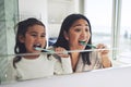 Mother, child and brushing teeth in dental hygiene, morning routine or healthcare together by mirror in bathroom. Happy Royalty Free Stock Photo