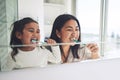 Mother, child and brushing teeth in morning routine, dental hygiene or healthcare together by mirror in bathroom. Happy Royalty Free Stock Photo