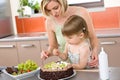 Mother and child with chocolate cake in kitchen Royalty Free Stock Photo