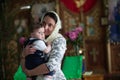 Mother with child in church. An infant in the arms of the godmother in the temple