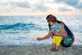 Mother and child collect pebbles on beach Royalty Free Stock Photo