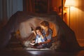 Mother and child daughter with a book and a flashlight before go Royalty Free Stock Photo