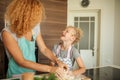 Mother and child daughter girl having fun while making dinner at the kitchen. Royalty Free Stock Photo