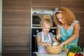 Mother and child daughter girl having fun while making dinner at the kitchen. Royalty Free Stock Photo