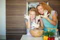 Mother and child daughter girl having fun while making dinner at the kitchen. Royalty Free Stock Photo