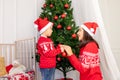 Mother and child decorate the Christmas tree before the new year or Christmas in the children`s room with a new year`s interior Royalty Free Stock Photo