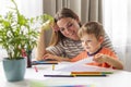 Mother and child drawing with pencils sitting at the desk at home Royalty Free Stock Photo