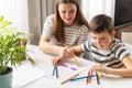 Mother and child drawing with pencils sitting at the desk at home Royalty Free Stock Photo