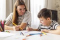 Mother and child drawing with pencils sitting at the desk at home Royalty Free Stock Photo