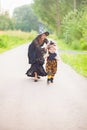 Mother and child dressed like witches, having fun outdoors.