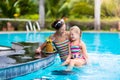 Mother and child drink juice in swimming pool Royalty Free Stock Photo