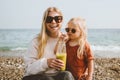 Mother and child drinking detox kiwi smoothie summer family vacations on beach healthy lifestyle Royalty Free Stock Photo