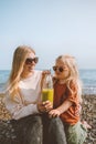 Mother and child drinking smoothie  outdoor summer vacations family on beach travel healthy lifestyle vegan organic beverage Royalty Free Stock Photo